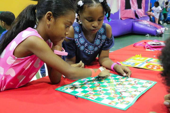 Avyanna Mohammed and Arianna Meloney play a classic game of snakes and ladders at Digicel’s games we used to play event at Centre of Excellence, Macoya on July 13. 