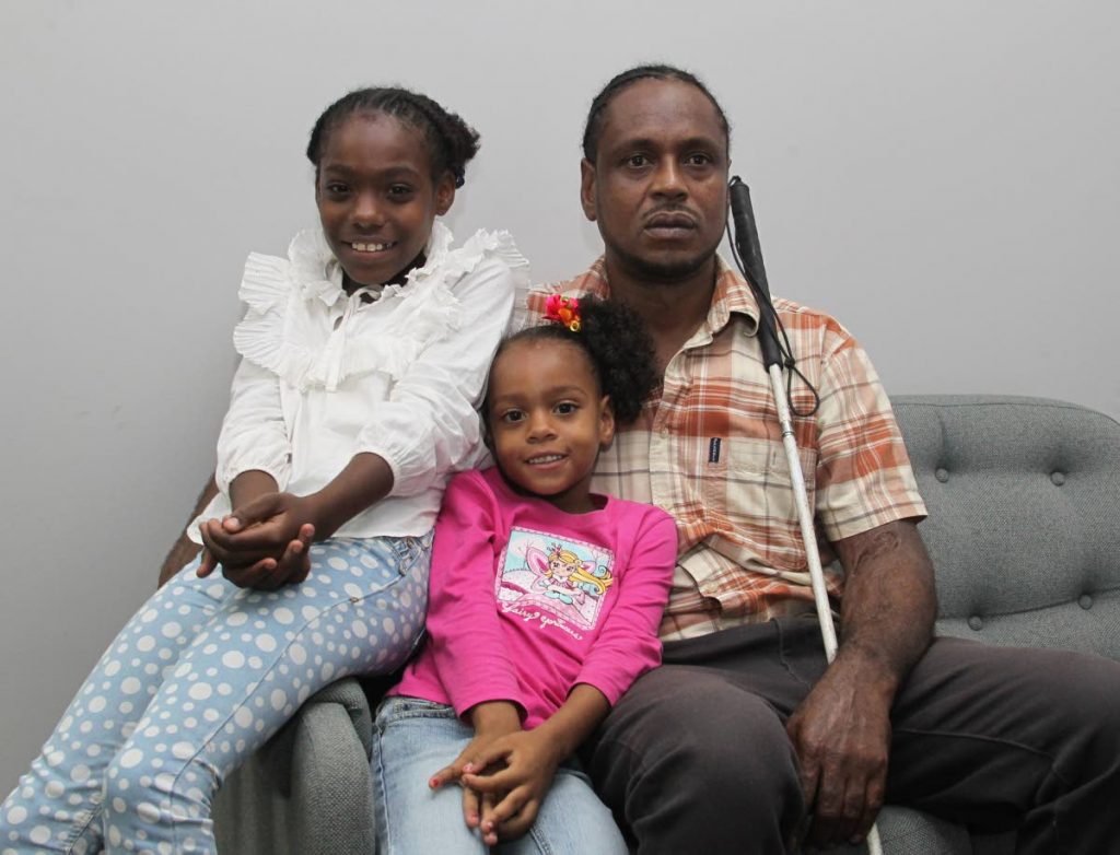 Lincoln Antoine, pleading for authorities to process his disability assistance claim, alongside his children, Melanie 9, and Africa 5.

Photo: Roger Jacob