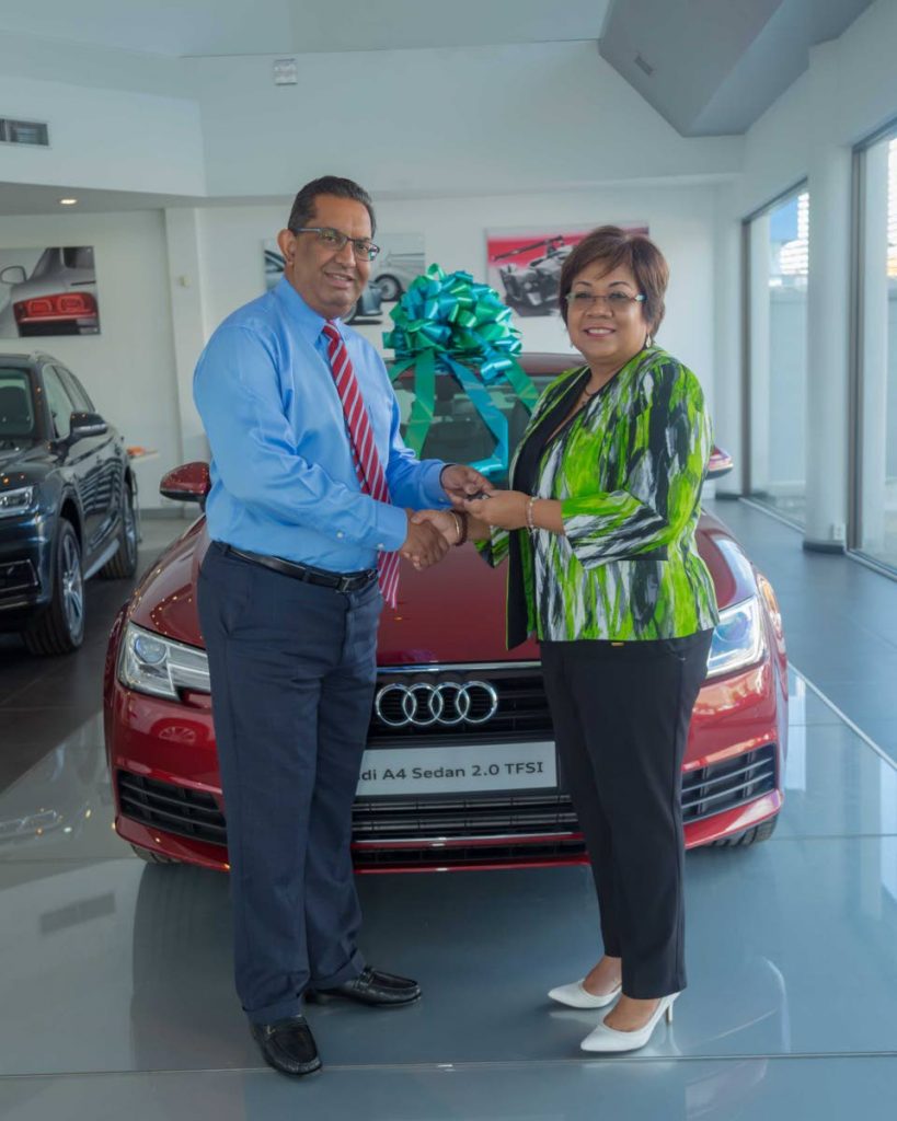 Reyaz Ahamad (left), Director, Southern Sales and Service, hands over the key of the Audi A4 sedan to Marlene Chin, Assistant Vice President, Marketing, Communications and Brand Experience, Sagicor Life Inc. The sedan is the Hole in One prize for Hole 7.
