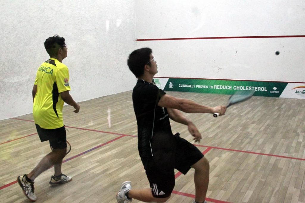 Michael Chin Lee of TT, right, plays Karan Chatani of Jamaica at the 2019 Junior Caribbean 
Area Squash Association Championships at the Queen’s Park Indoor Racquet Centre in 
St Clair. PHOTO BY ROGER JACOB