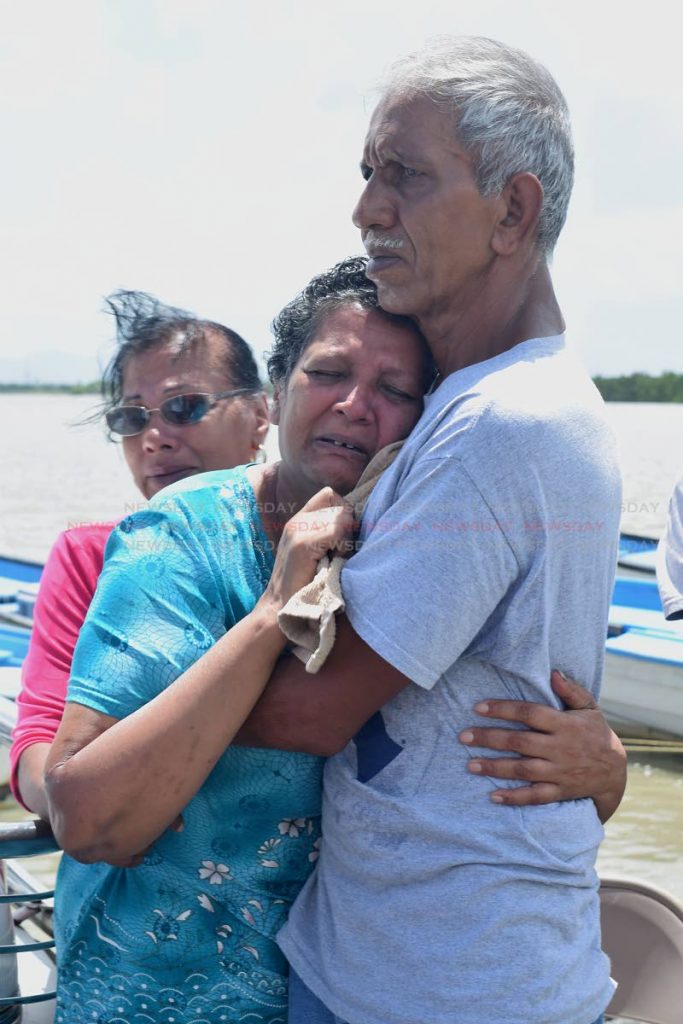 Grieving mother, Samoo Ali is consoled by her husband Nizam Ali as the body of her son Anand Rampersad is moved from the Orange Valley docks on Wednesday morning. Photo by Vidya Thurab