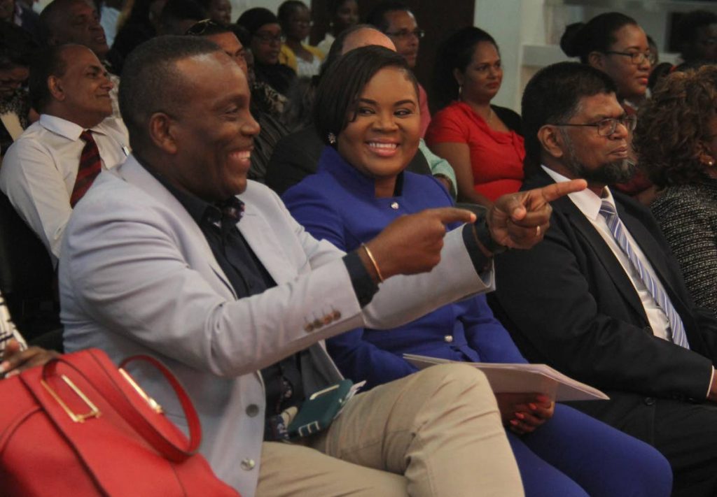Minister of Sport and Youth Affairs Shamfa Cudjoe,centre, shares a laugh with Member of Parliament for Tunapuna Esmond Forde,left, at the Rewards, Recognition and Cheque Presentation Ceremony, at the National Racquet Centre, Tacarigua yesterday.