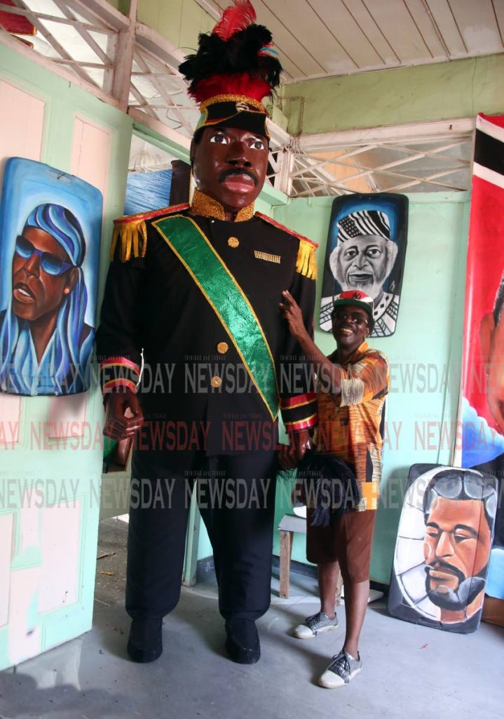 A statue of Marcus Garvey towers over its creator Art Brown at his studio in St James. The statue will be part of Emancipation Day celebrations tomorrow. PHOTOS BY SUREASH CHOLAI
