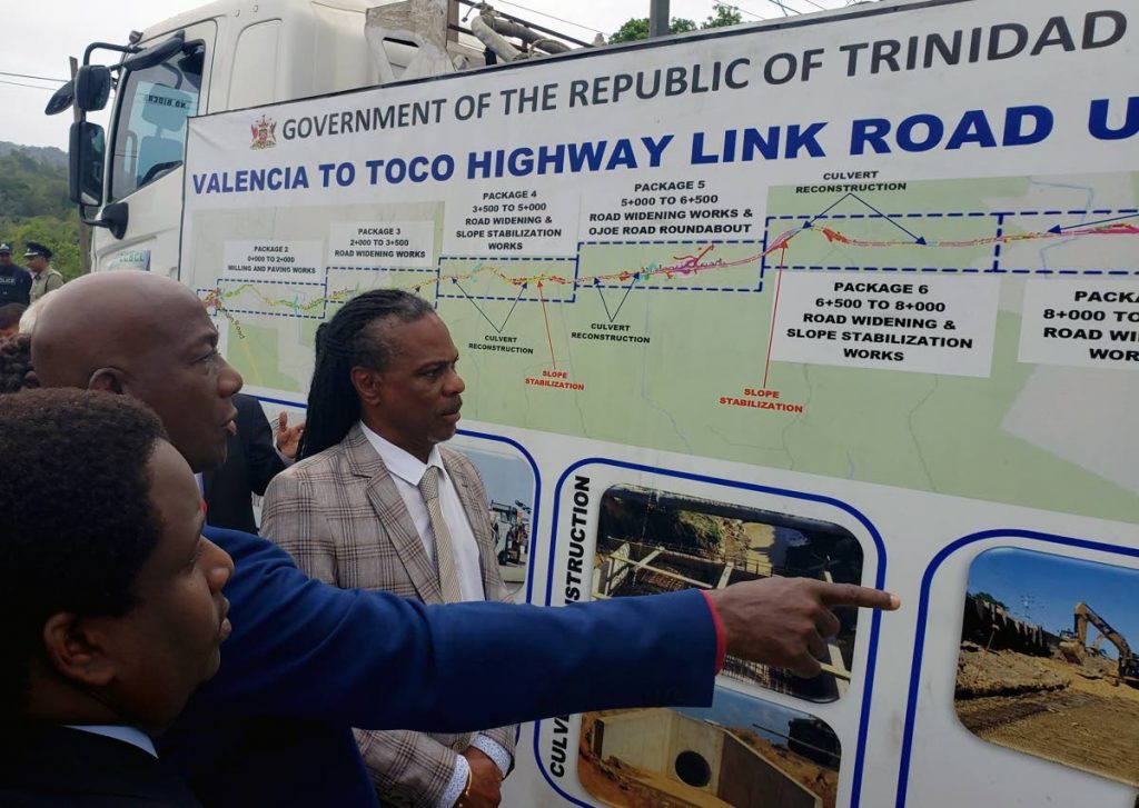Prime Minister Dr Keith Rowley, centre, Hayden Phillip, director of PURE, right, and Anton Balfour, senior project manager at PURE, left, examine an illustration of the road upgrade projects at the sod-turning ceremony for the Valencia to Toco Highway Link Road, Valencia Main Road, Valencia on March 27. FILE PHOTO