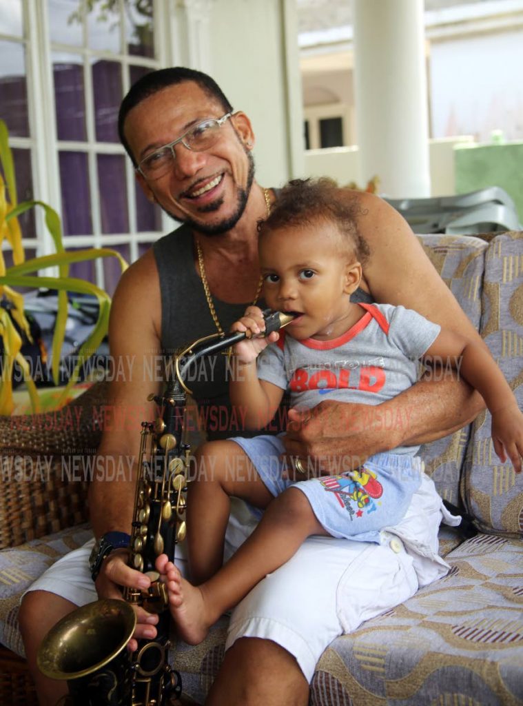 STILL FIGHTING: Saxophonist and retired policeman Pedro Lezama and his 18-month-old son Quan Keanu at their La Horquetta home last week.  PHOTO BY SUREASH CHOLAI