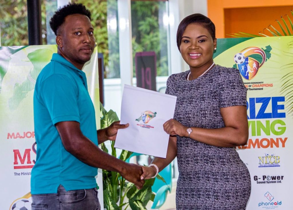 Sports Minister Shamfa Cudjoe distributes prizes for the Tobago Community Champion of Champions Football Tournament at the Orange Business Group Headquarters in Carnbee, last Tuesday. 