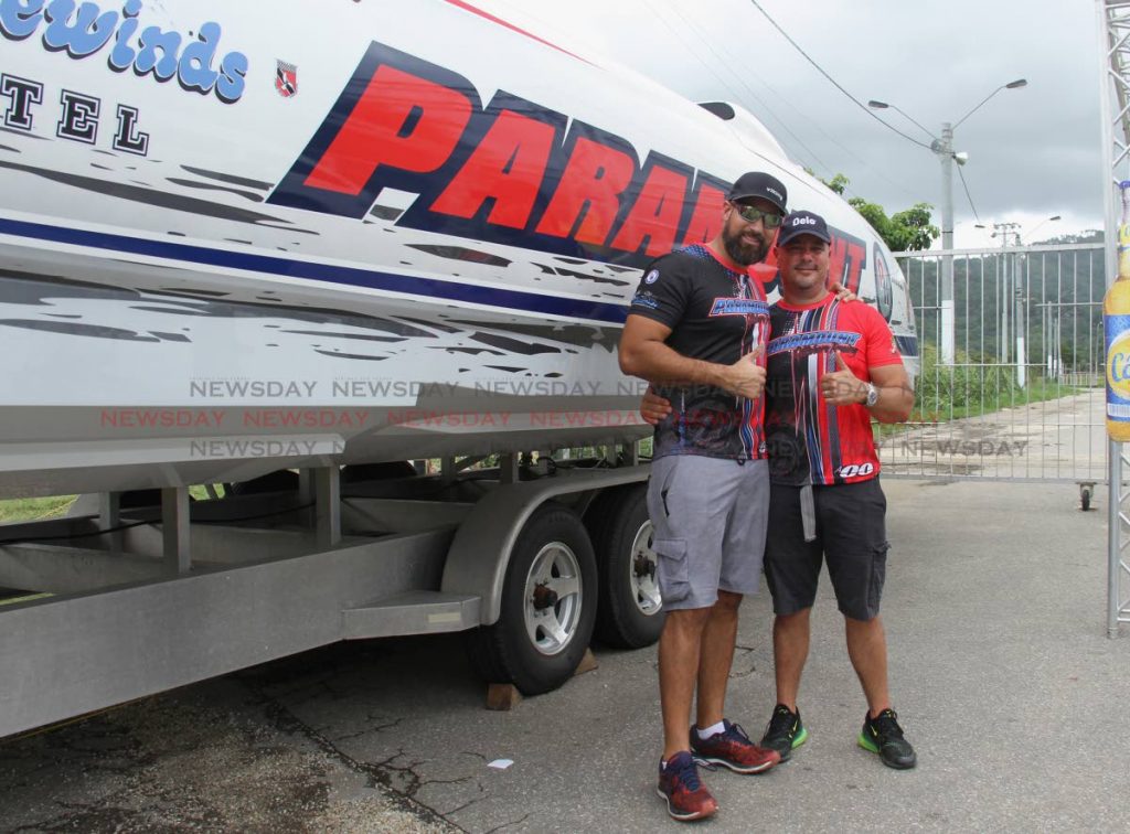 Crew member Adam Hive, left, and driver Jason Laing take a photo in front of their boat Paramount at the Great Race 2019 boat show, Queen's Park Savannah yesterday. PHOTO BY AYANNA KINSALE