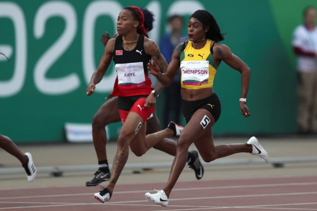 Elaine Thompson of Jamaica, right, on her way to gold in the women's 100m final at the Pan American Games in Lima, Peru, yesterday. At left is TT sprinter Michelle-Lee Ahye. 