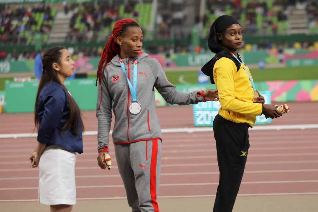 Gold medallist Elaine Thompson of Jamaica (right) and silver medallist Michelle-Lee Ahye of TT stand on the podium for the women’s 100m at the Pan American Games in Lima, Peru on Wednesday. 