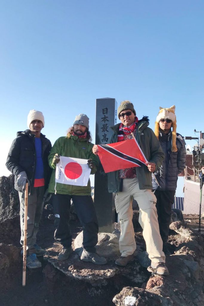 The Samaroo family at the Mt Fuji summit with TT and Japanese flags. From left to right: Gabriel Samaroo, their guide Jack Fukushima, Dave Samaroo and Sebastian Samaroo.
