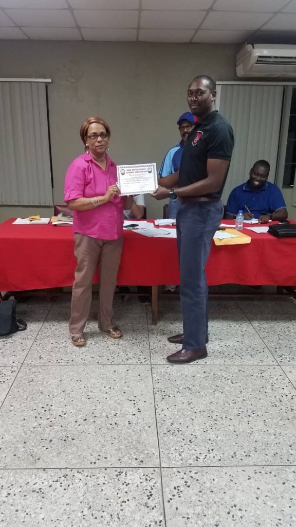 Umpire Carlton Best, right, collects his Cricket West Indies certification from Anne Marie Charles, secretary of the TT Cricket Umpires and Scorers Union two weeks ago. PHOTO COURTESY TT CRICKET BOARD
