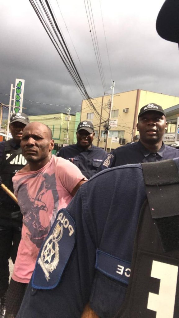 Police take prison escapee Dillon Clarke into custody on Hollis Avenue, Arima during borough day celebrations on Saturday. PHOTO SOURCE SOCIAL MEDIA