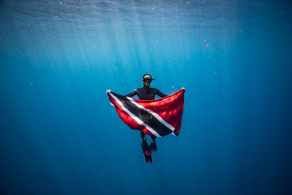 Shivani Goberdhan poses with the TT flag in West Bay, Honduras. PHOTO BY ALEX ST JEAN