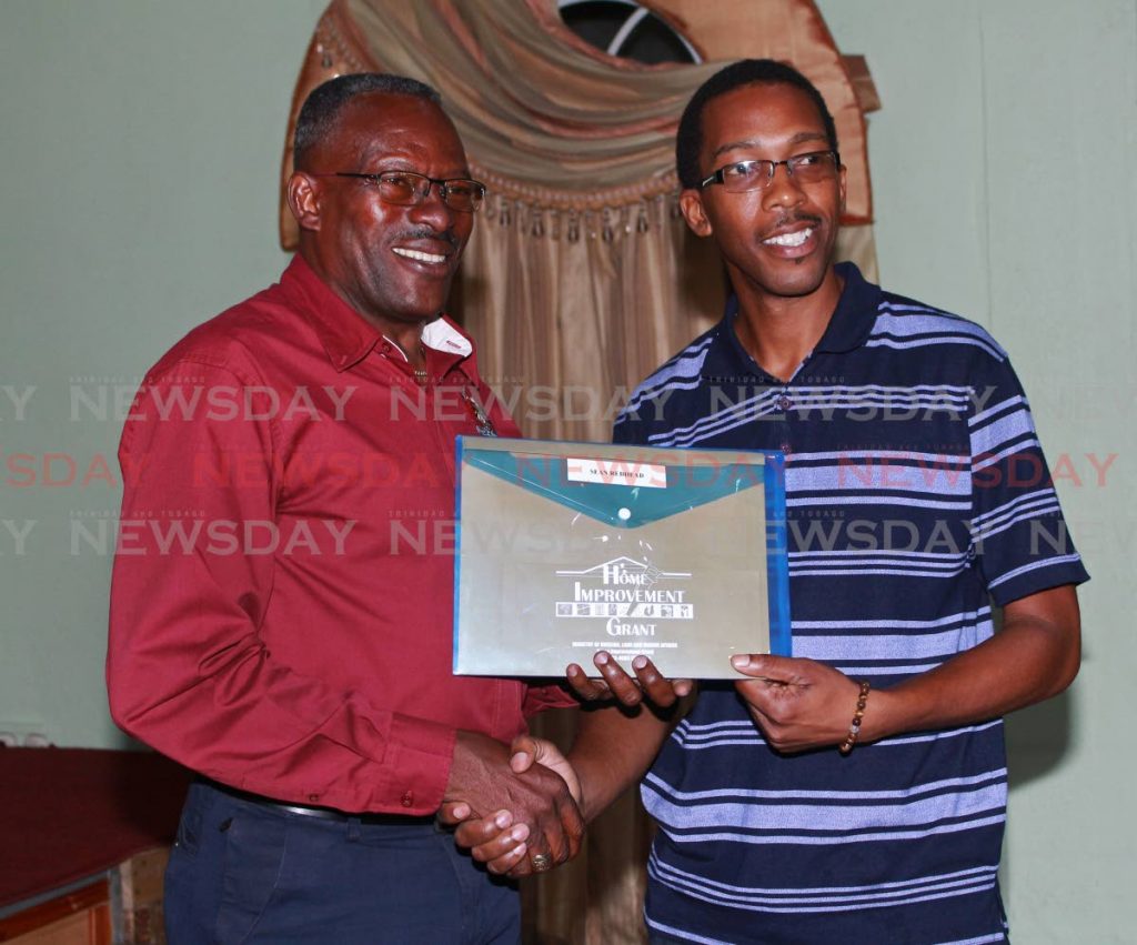 Minister of Housing and Urban Development Edmund Dillion presenting a recipient with his Grant at the Point Fortin Borough Town Hall on Wednesday.

PHOTO BY: CHEQUANA WHEELER