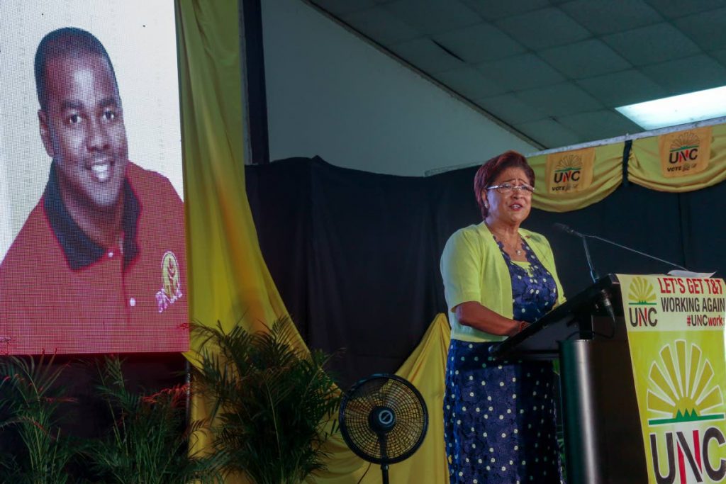 UNC political leader Kamla Persad-Bissessar speaks to supporters during a rally on Sunday at the Couva South multi-purpose complex.  Behind her on a screen is a photo of PNM senator Foster Cummings. 