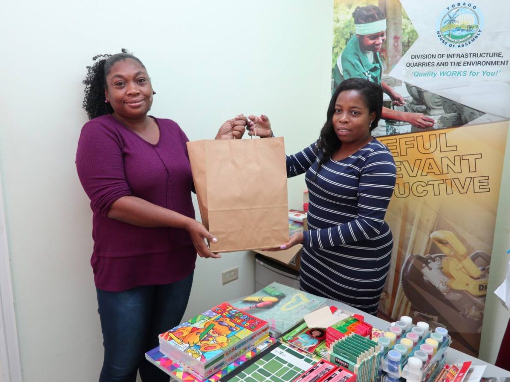 Office assistant Maria Roberts, left, collects a back-to-school package for the women's programme section at the URP head office, Shaw Park.
