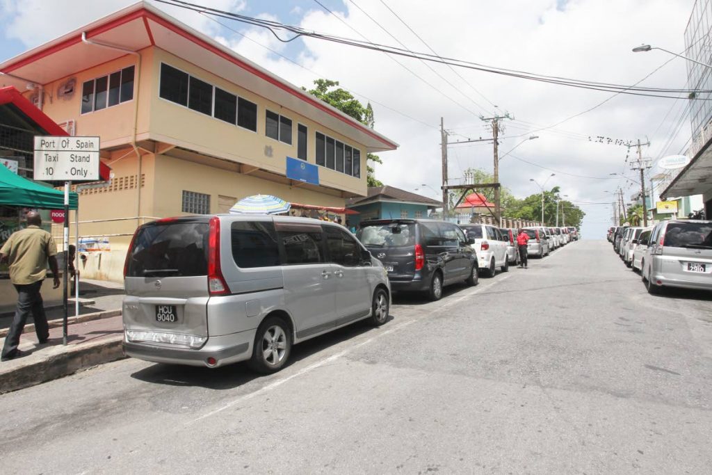 In this file photo, cars belonging to taxi drivers plying the San Fernando to Port of Spain route line up on each side of the road between Library Corner and Harris Promenade in San Fernando. 