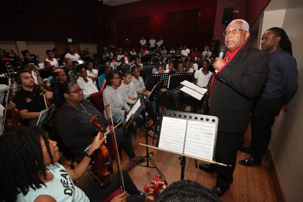 Minister of Education Anthony Garcia speaks to members of the Caribbean Youth Orchestra on Thursday, at City Hall, Port of Spain. Behind him is conductor Akua Leith. 