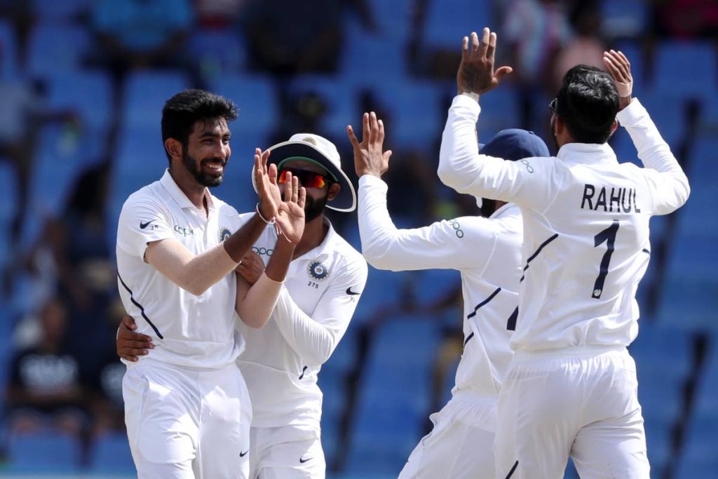 India's Jasprit Bumrah, left, celebrates with Lokesh Rahul after taking the wicket of West Indies' Shai Hope during day four of the first Test at the Sir Vivian Richards cricket ground in North Sound, Antigua, Sunday.