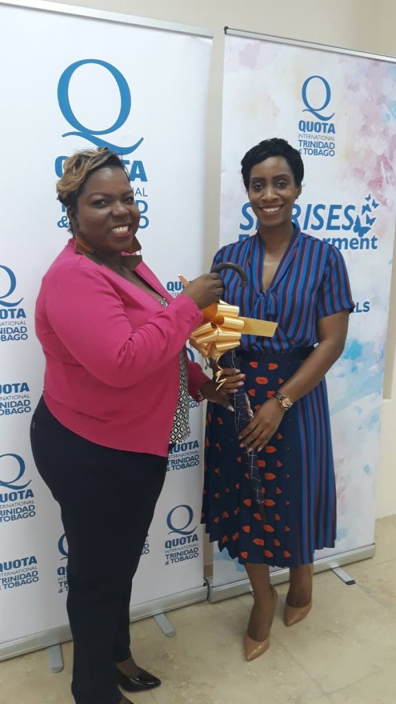 Business owner Solange Richardson is presented with a 
token by QuotaTT secretary Chantal LaRoche.