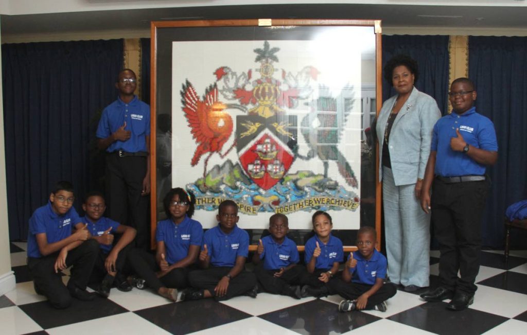 NATIONAL PRIDE: Members of the Lego Club of TT pose with President Paula-Mae Weeks at her office yesterday, after presenting to her a replica of this country’s coat of arms. 