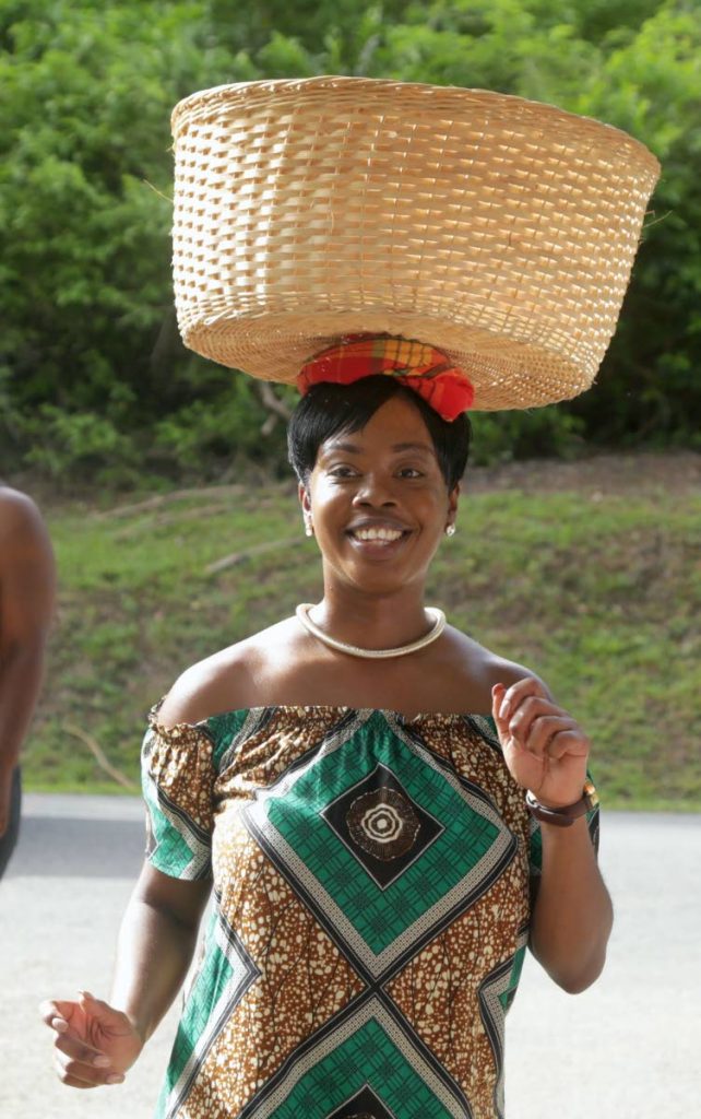 Tourism and Culture Secretary Nadine Stewart-Phillips balances a basket on her head at the Black Rock Sea Festival earlier this year. PHOTO COURTESY THA 
