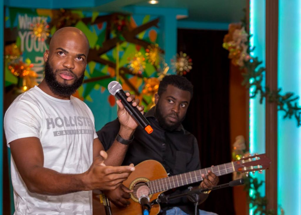 Poet Dr Kern Johnson, left, at an Open Mic event hosted by the Tobago Writers Guild at Apex Bar and Grill recently. 