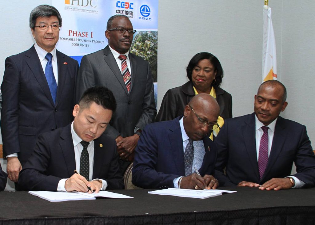 China Gezhouba Group executive vice president Zhou Xing, left, and HDC chairman Newman George sign documents for phase one of a 5,000 unit housing construction project at Hyatt Regency, Port of Spain on May 17. Also present are China's ambassador Song Yumin, back left, Housing Minister Edmund Dillon and Port of Spain South MP Marlene McDonald. Government announced last Thursday that it had terminated the contract. PHOTO BY AYANNA KINSALE