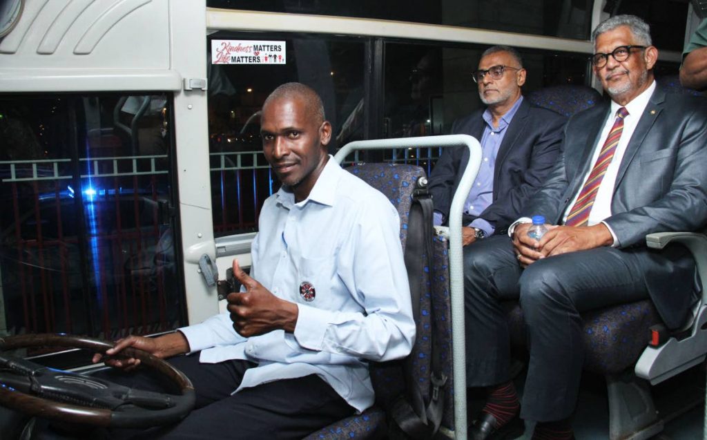 Minister of Works and Transport Rohan Sinanan, left,  and Chairman of PTSC Edwin Gooding sit in one of the refurbished buses at South Quay Port-of-Spain on Friday. 