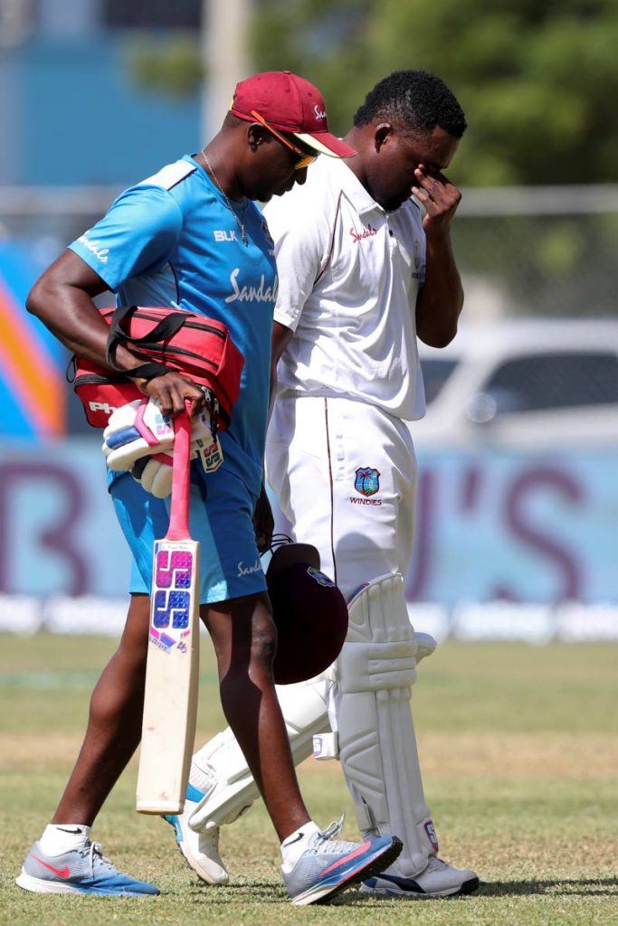 West Indies' batsman Darren Bravo leaves the field escorted by a member of his team during the first session of day four of the second Test at Sabina Park in Kingston, Jamaica, Monday. (AP)