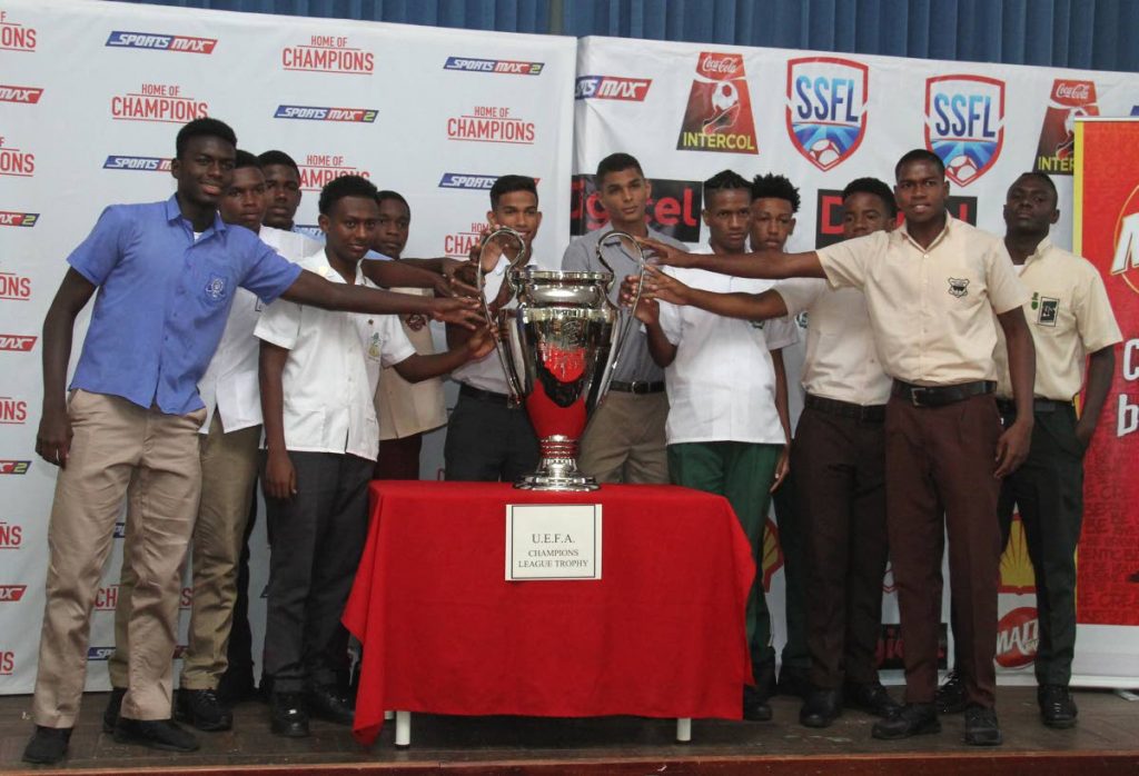 Footballers from various secondary schools touch the UEFA Champions League trophy yesterday during the launch of the Secondary Schools Football League.