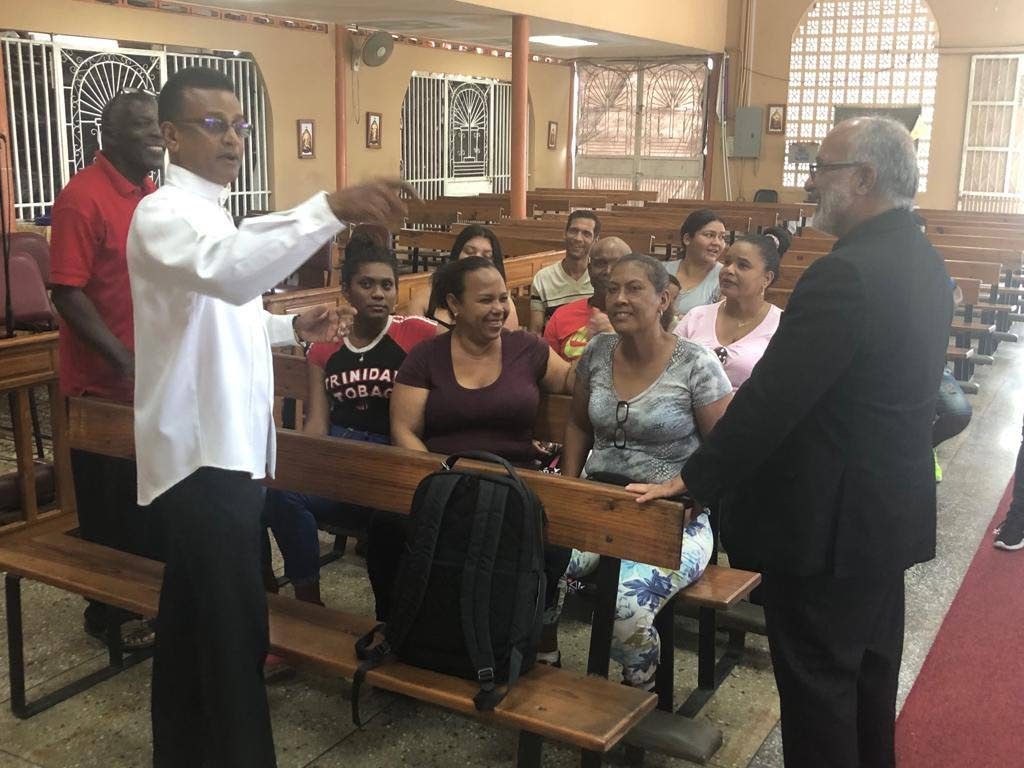 El padre Robert Christo, a la izquierda, habla con el obispo venezolano Jaime José Villarroel Rodríguez durante una visita reciente a la iglesia en Penal.

