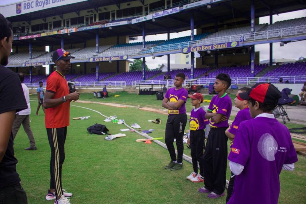 TKR spinner Khary Pierre talks to youngsters at the Queen’s Park Oval in St Clair. 