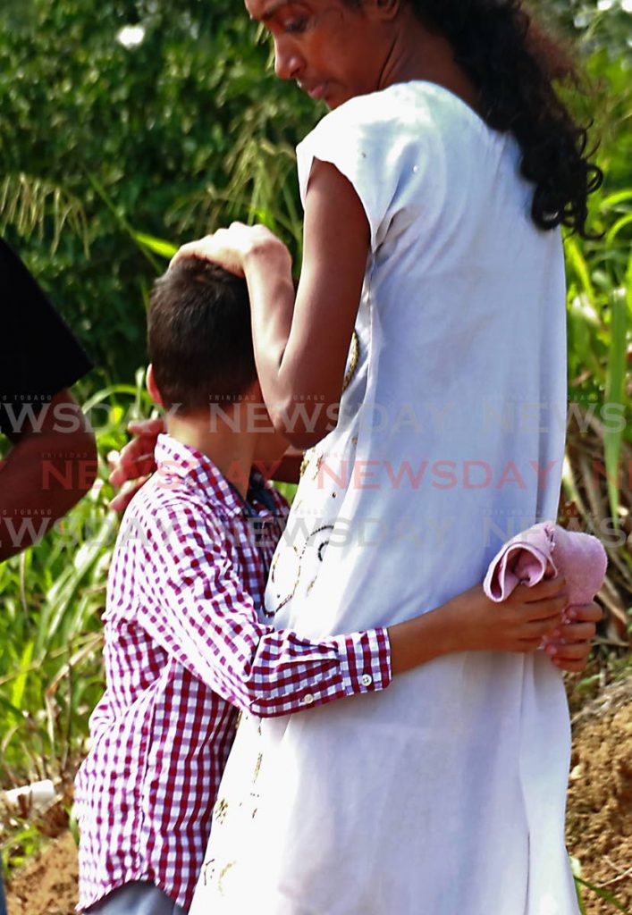 Son of the late Harricharan Ramsundar is embraced at funeral service at their home in Phulo Drive, La Brea Trace, Siparia. PHOTO BY: MARVIN HAMILTON