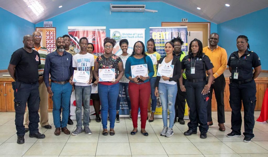 Participants in the disaster preparedness and management workshop with their certificates at the Calder Hall Multi-purpose Facility. They are flanked by staff of the Tobago Emergency Management Agency (TEMA), including its director Allan Stewart (left) and Youth Development Officer II in the Department of Youth Affairs Lyndon Wilson (front row, second from right).