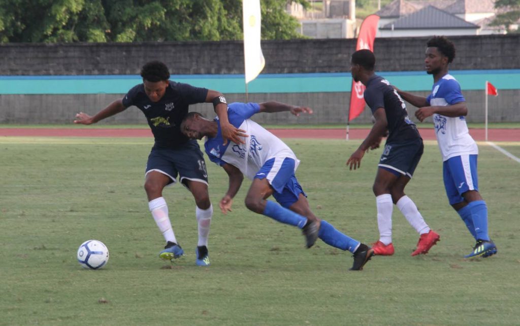 Decklan Marcelle (left) of Naparima tries to get past his Presentation San Fernando opponent during yesterday's game at the Manny Ramjohn Stadium, Marabella. PHOTO BY VASHTI SINGH.