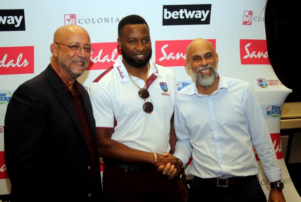 Newly-appointed West Indies T20 
and ODI captain Kieron Pollard,centre, is all smiles during a Cricket West Indies media conference,held on Monday, at the Hilton Trinidad, St Ann’s to announce the new captaincy. At left, CWI president Ricky Skerritt and CWI cricket ambassador Jimmy Adams,right, look on. 