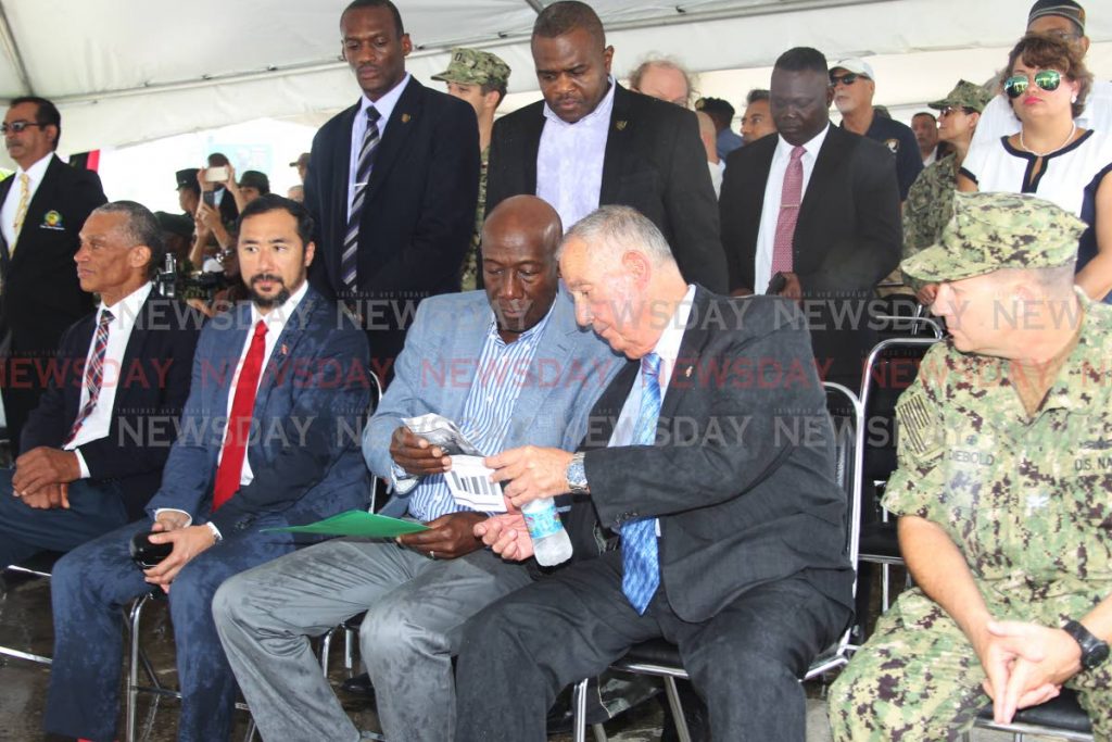 Prime Minister Dr Keith Rowley, centre, is deep in consultation with US Ambassador Joseph Mondello yesterday as Minister of National Security Stuart Young and Minister of Foreign Affairs Dennis Moses look on at the closing ceremony to mark the end of the visit by the USNS Comfort medical ship to TT on Tuesday. PHOTO BY LINCOLN HOLDER