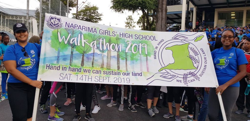 Naparima Girls' High School students raise awareness on protecting the environment during a walkathon in San Fernando on Saturday. 