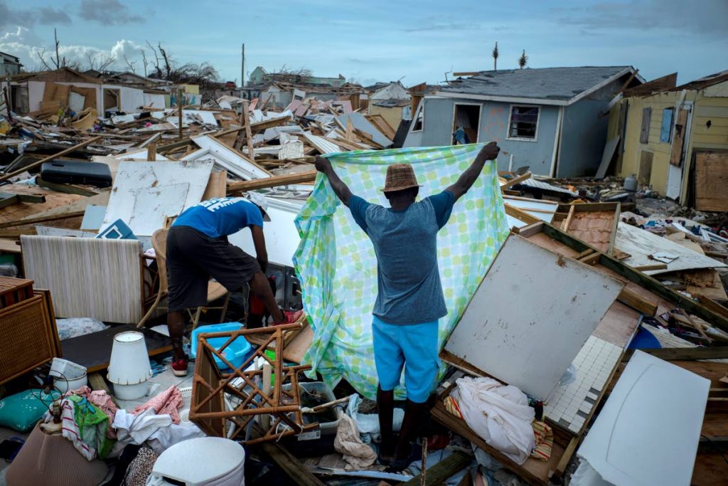 Immigrants from Haiti recover their belongings from the rubble in their destroyed homes, in the aftermath of Hurricane Dorian in Abaco, Bahamas. AP PHOTO