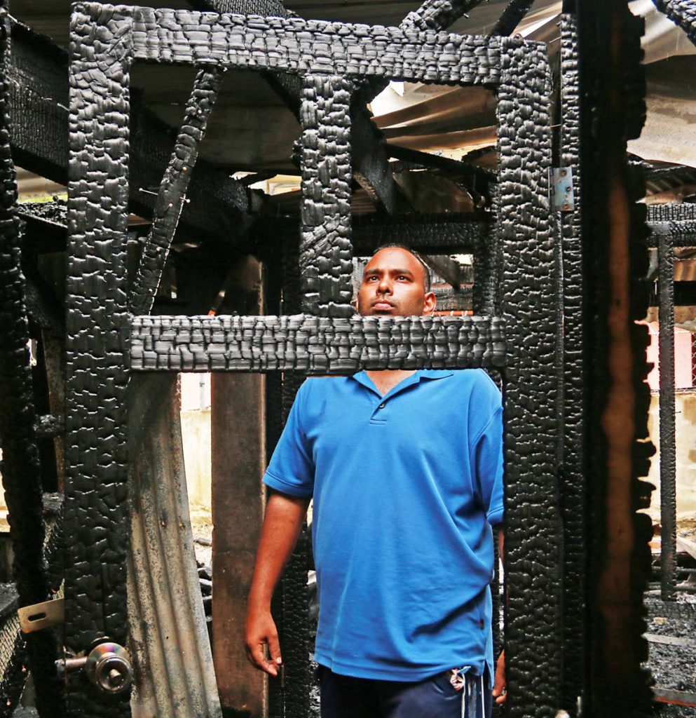ALL IS LOST: Pradeep Singh looks at a burnt door frame in his house at Allen Street in Gasparillo which was gutted by fire during the early morning hours yesterday. 