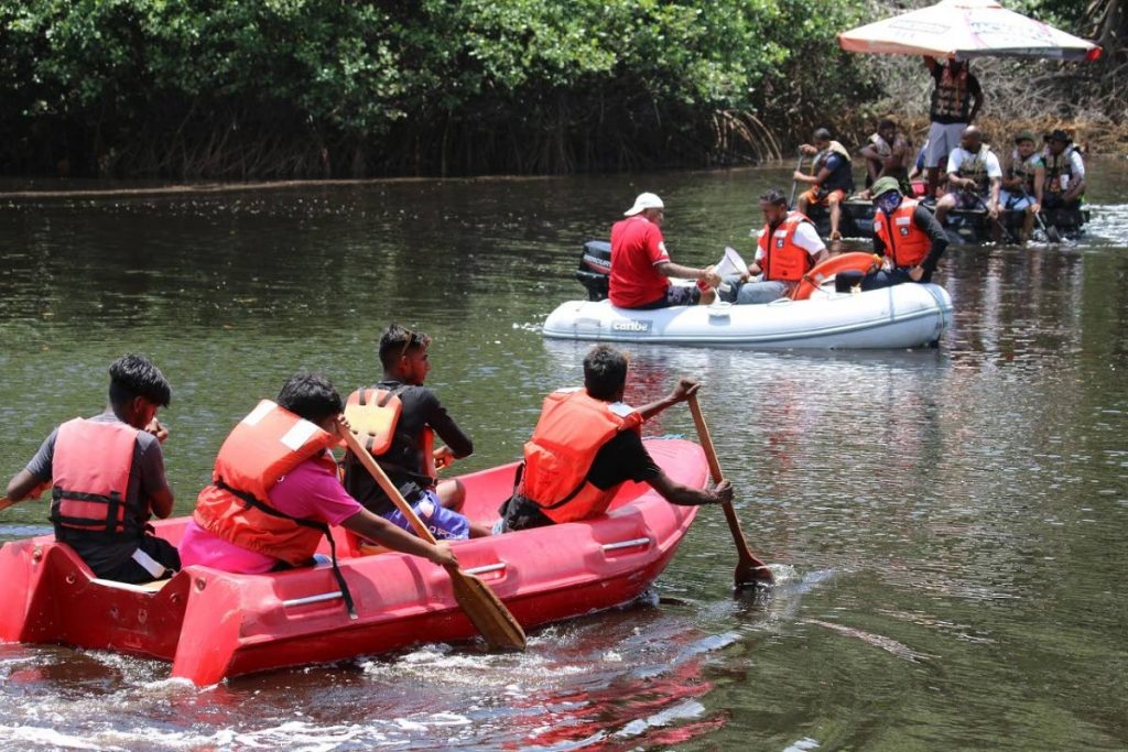 Raft derby teams paddle down the  Mitan River, Manzanilla.