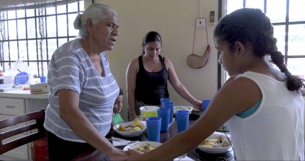 Captura de pantalla de Vecinos Más Cercanos: una familia venezolana reza por bendiciones en su comida y para otros que no tienen.