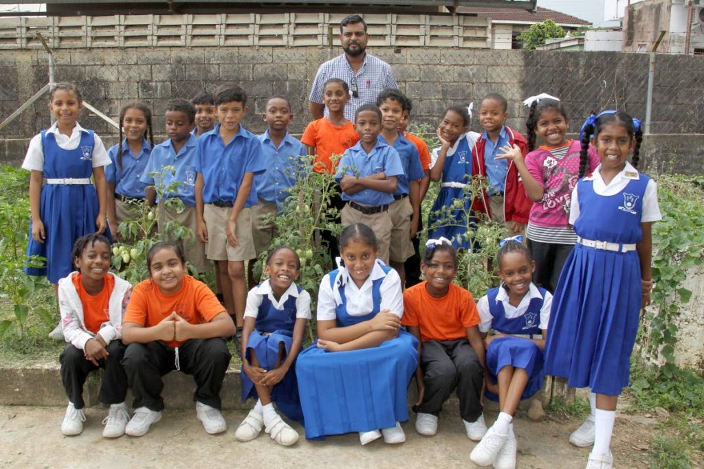 THINK GREEN: Standard II teacher Kirk Satram with students in the Tunapuna Presbyterian Primary School’s garden. 