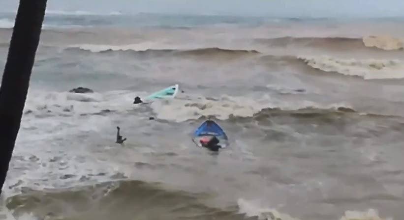 DANGER MOVE: A screen-grab from a video uploaded to social media shows a man raising his arms as he desperately tries to reach his boat in the raging sea on Sunday during Tropical Storm Karen's passage. Several fishing boats sank in the rough sea.