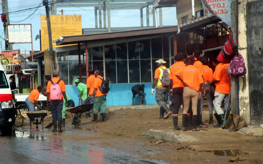 Cepep workers were busy yesterday removing slush and debris from the Eastern Main Road in San Juan yesterday.   PHOTO BY SUREASH CHOLAI