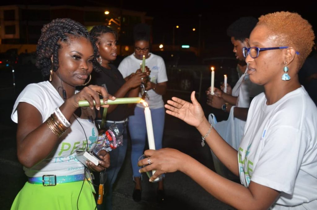 JCI Peace Project chair Darianne Phillips, left, lights a candle at the International Day for Peace on Saturday. 