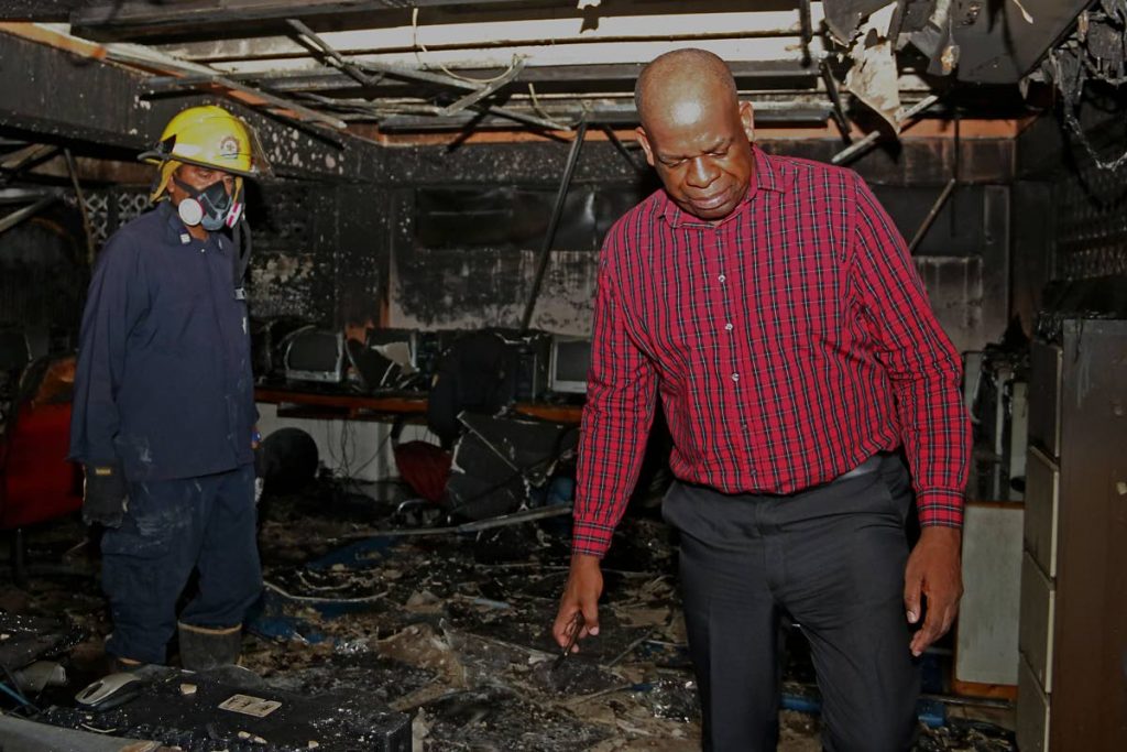 STILL THANKFUL: Minister in the Ministry of Education, Dr Lovell Francis, looks at the damage to the computer lab of the Princes Town RC School after a fire yesterday.  
