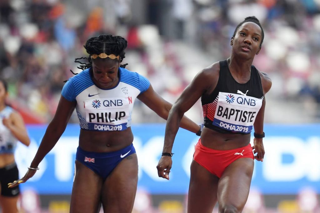 TT’s  Kelly-Ann Baptiste (R) and Britain’s Asha Philip compete in the Women’s 100m heats at the 2019 IAAF World Athletics Championships at the Khalifa International stadium in Doha, yesterday. (AFP PHOTO)