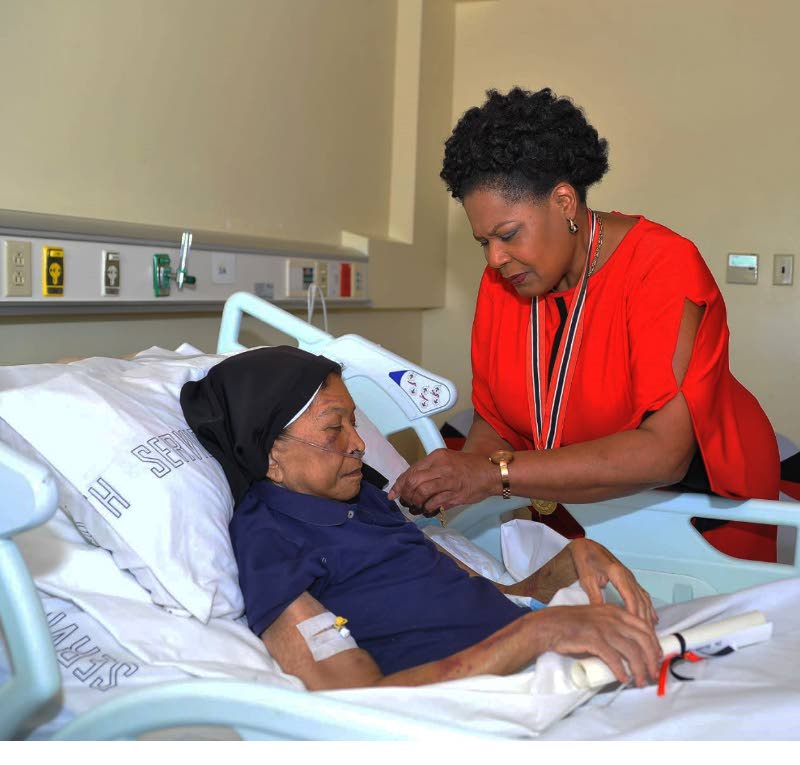 LIFETIME OF SERVICE: President Paula-Mae Weekes pins the Medal of Merit (Gold) on the garment of Dr Sister Phyllis Warfe last Friday at the Scarborough General Hospital in Tobago. PHOTO COURTESY OFFICE OF THE PRESIDENT